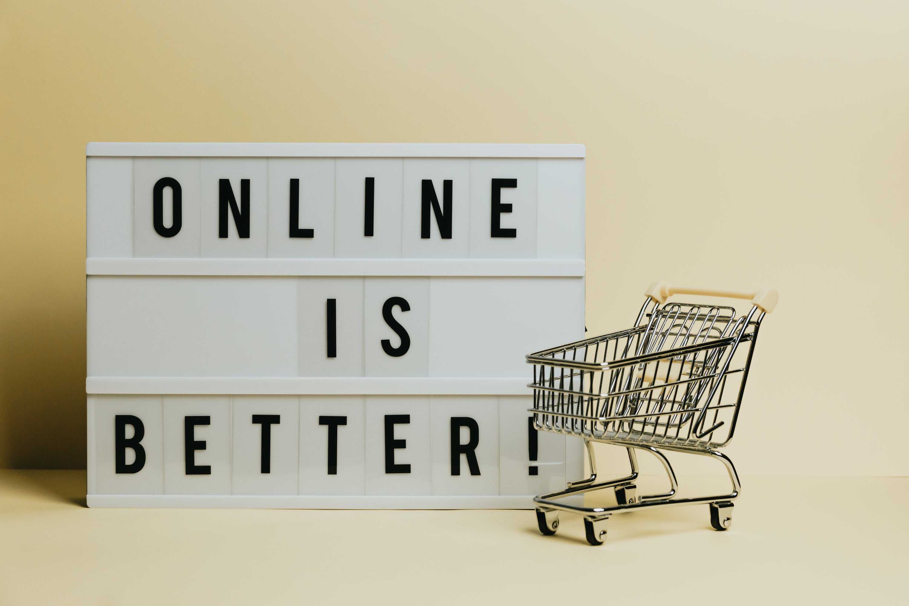 sign-says-online-is-better-with-a-small-shopping-cart